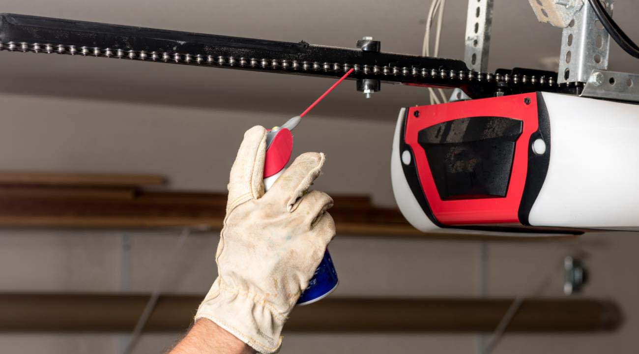Technician Performing Maintenance on Garage Door Chain Technician Performing Maintenance on Garage Door Chain