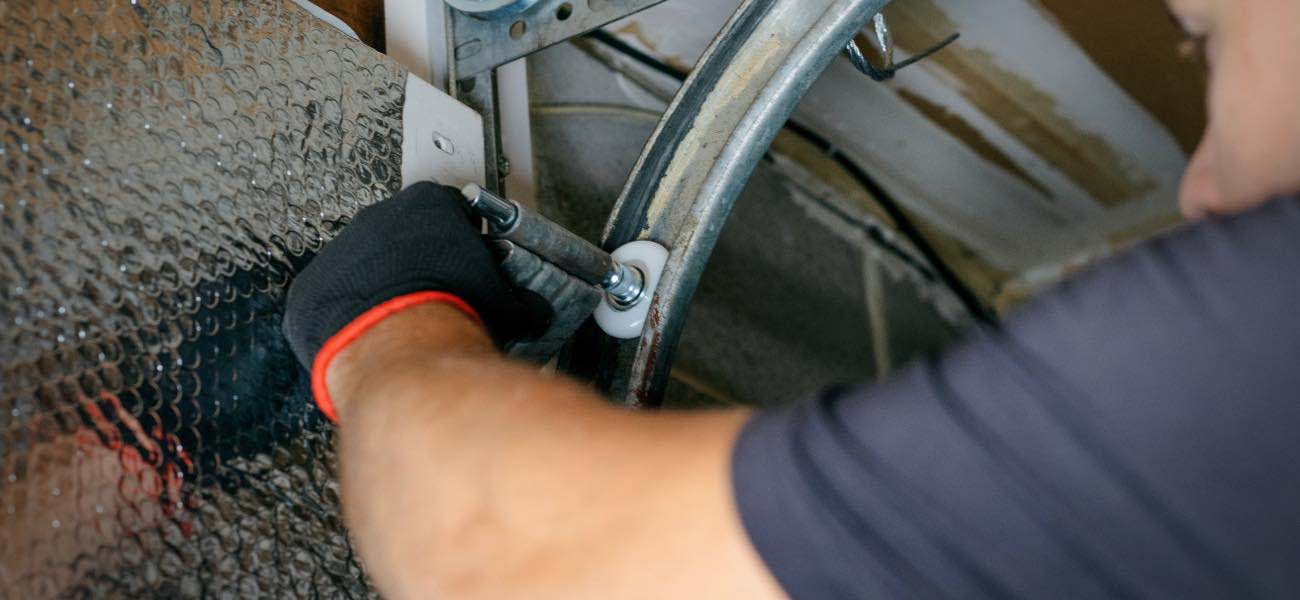 Precision Technician Performing Maintenance on Garage Door Precision Technician Performing Maintenance on Garage Door